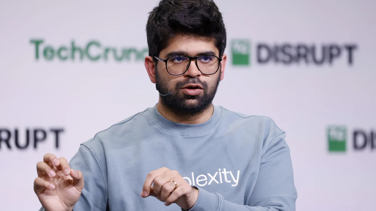 Aravind Srinivas, Perplexity CEO, speaking at TechCrunch Disrupt 2024 in black-framed glasses and a pale blue sweatshirt